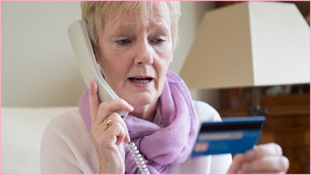 Older woman on the phone, holding as credit card