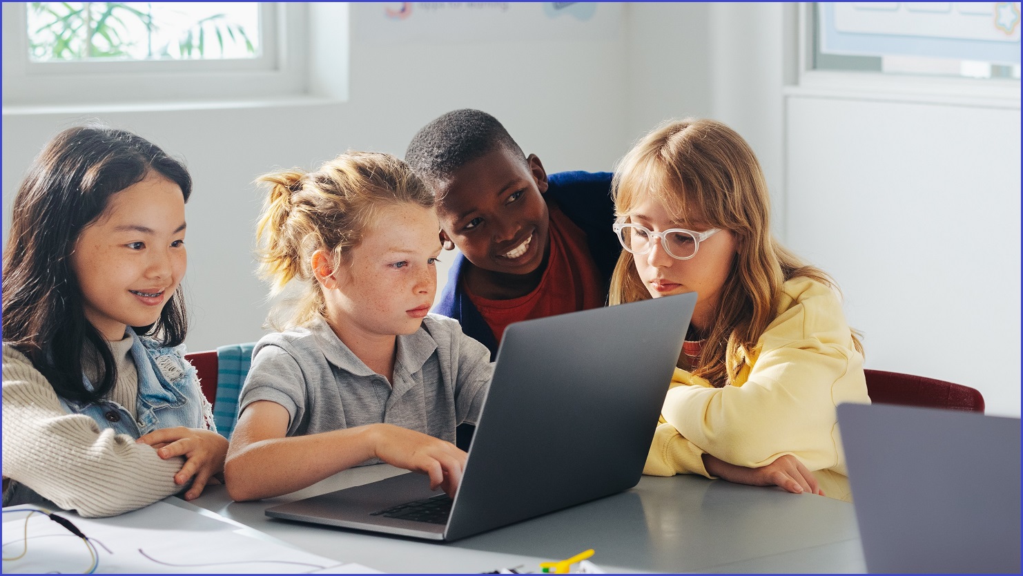 Four children sharing a laptop