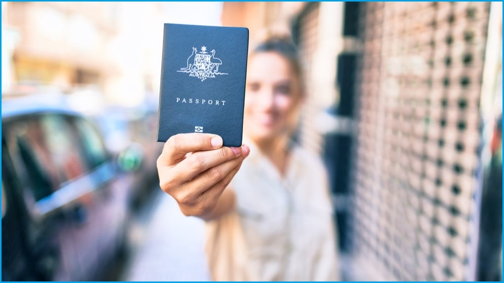 Woman holding up an Australian passport