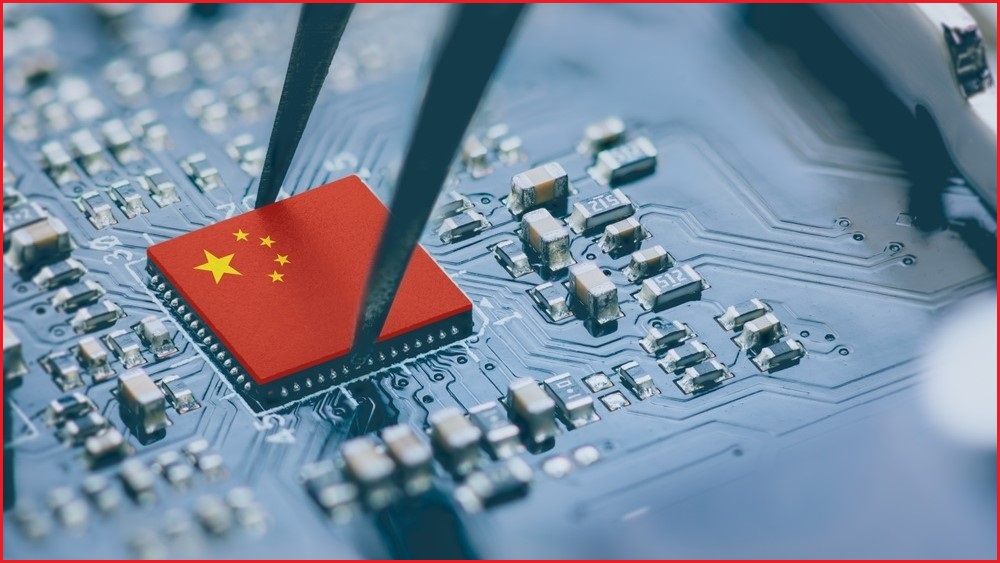 A microchip topped by a China flag being inserted onto a motherboard.