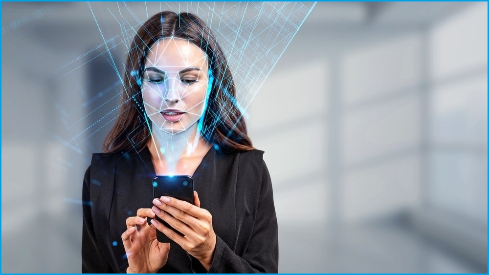 Woman typing on phone with blue biometric scanning light on her face