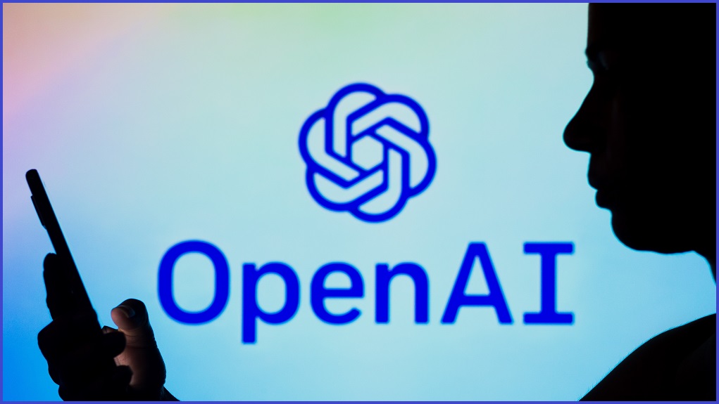 The OpenAI logo foregrounded with a silhouette of a person using their phone.
