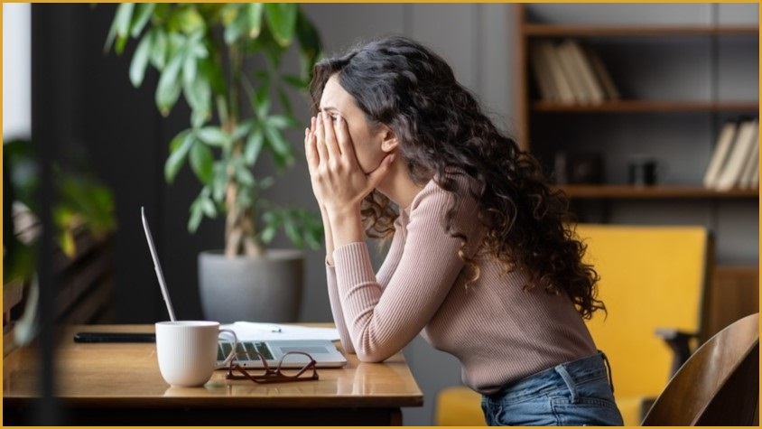 Woman sitting at computer looking disappointed,