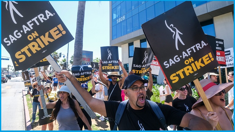 Strikers in a picket line holding signs that read 'SAG-AFTRA ON STRIKE!'