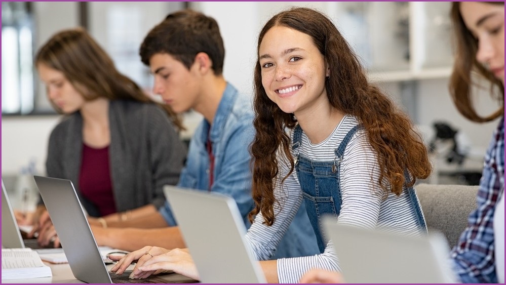 A row of girls and boys using computers
