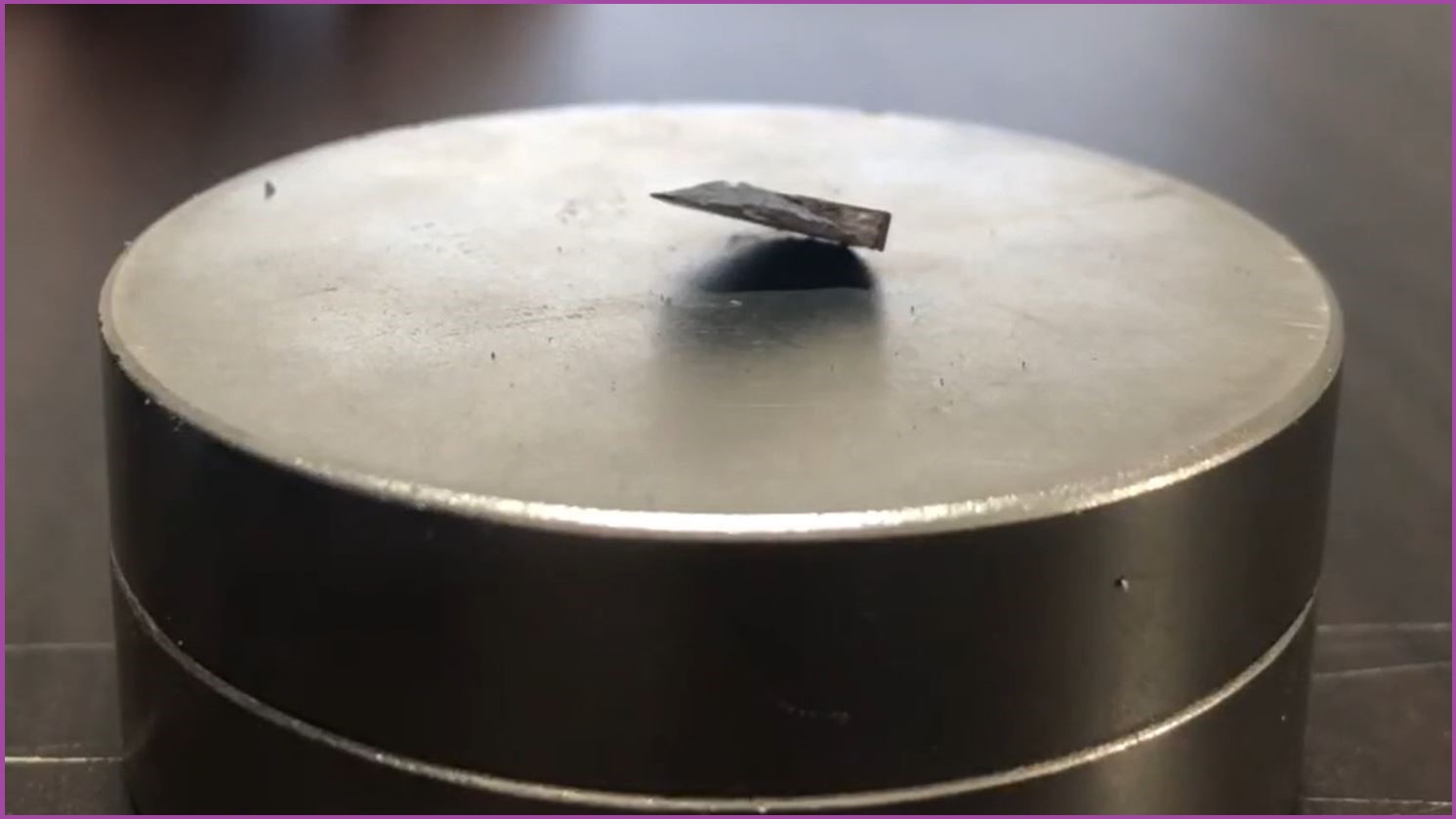 Screenshot of a video where the small LK-99 shard hovers on a magnet.