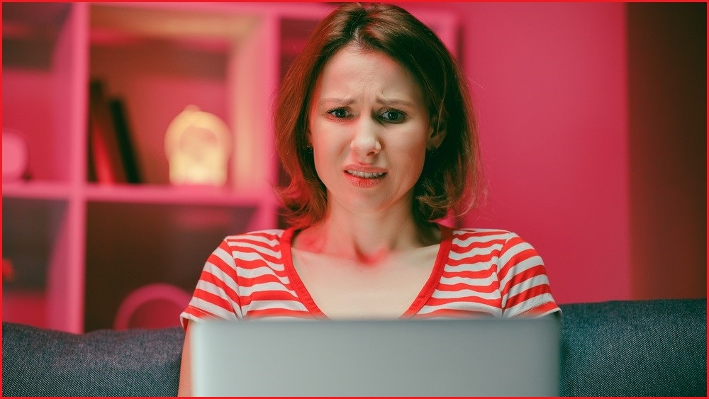 Woman looking at computer screen with concerned look on her face