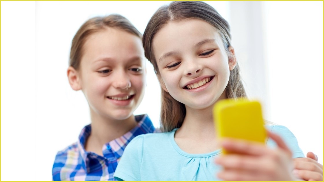 Two girls looking at a phone screen.
