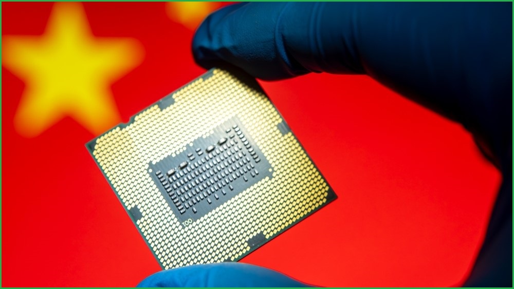 A close up of a gloved hand holding a computer chip. The background is a large Chinese flag.