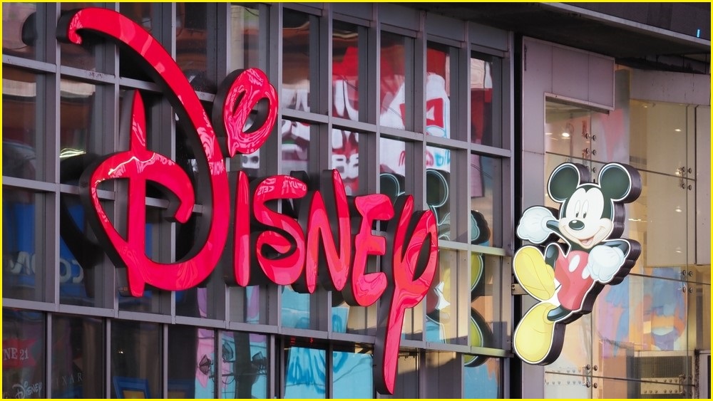 A close up of the Disney logo and a small Mickey Mouse character on the side of a Disney store.