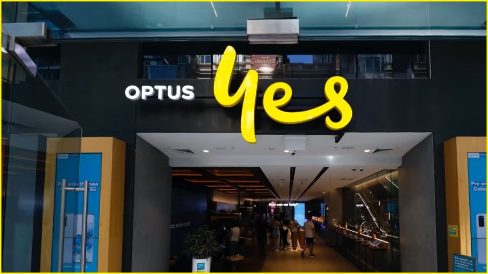 A medium shot of the Optus 'Yes' logo above the front entrance of an Optus store.