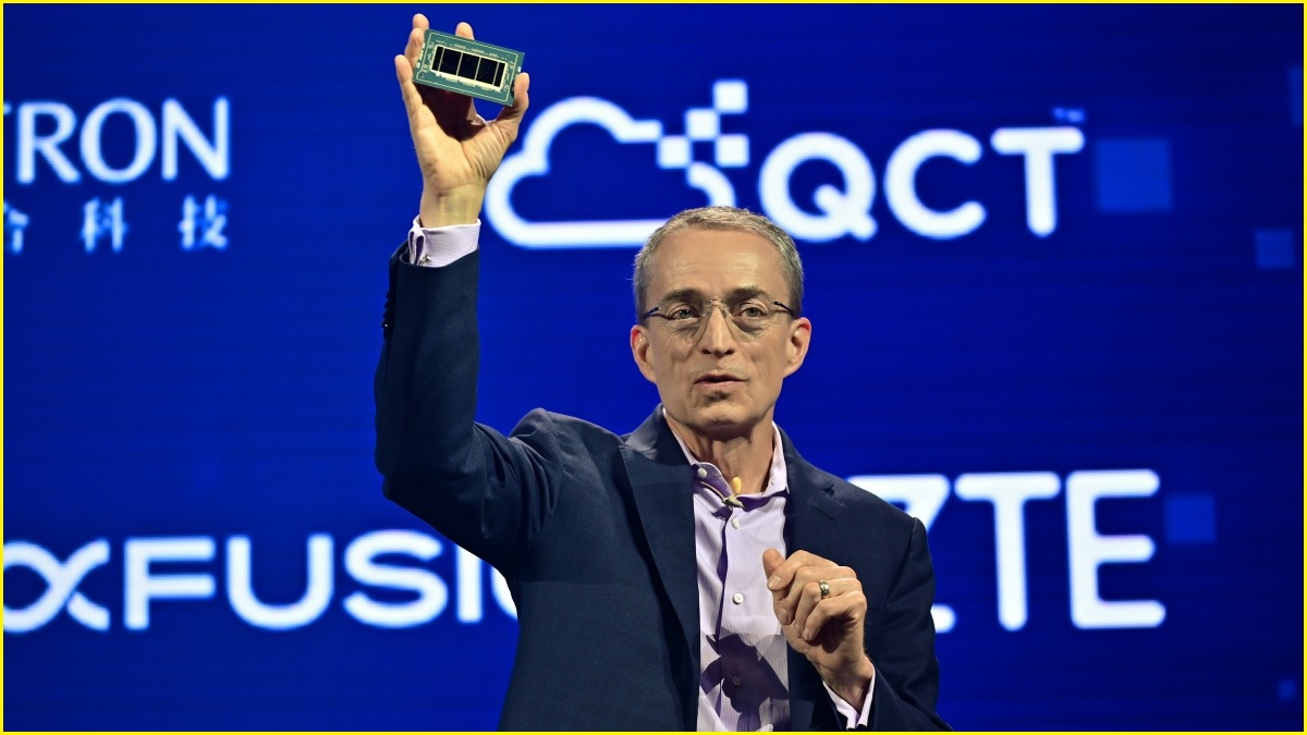 A medium shot of a middle-aged man in a suit jacket holding up a computer chip at a business announcement.