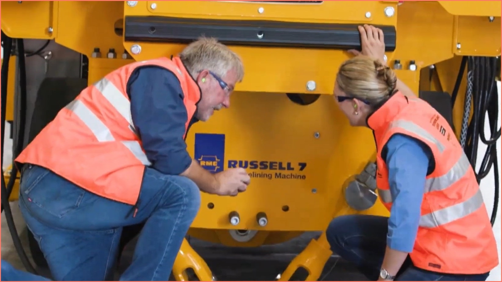 Russell Mineral Equipment workers examining machine.