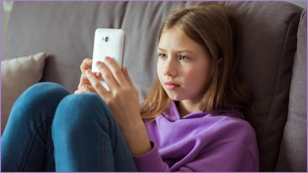 Young girl looking at a phone screen.