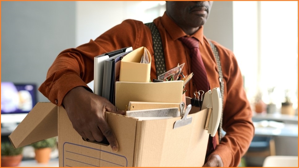 Man leaving workplace woith his belongings after being fired.