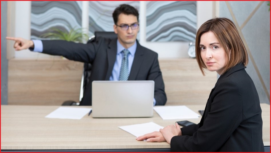 Boss pointing finger at door while employee looks upset.