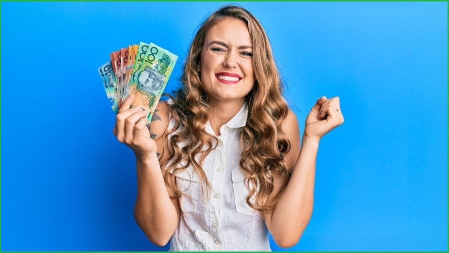 Woman celebrating, holding a fistful of Australian dollars.