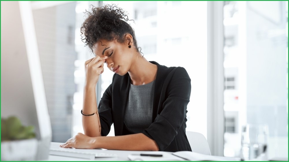 Woman sitting at her desk, tired.