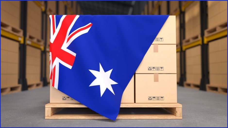 Australian flag draped over palette of cardboard boxes.