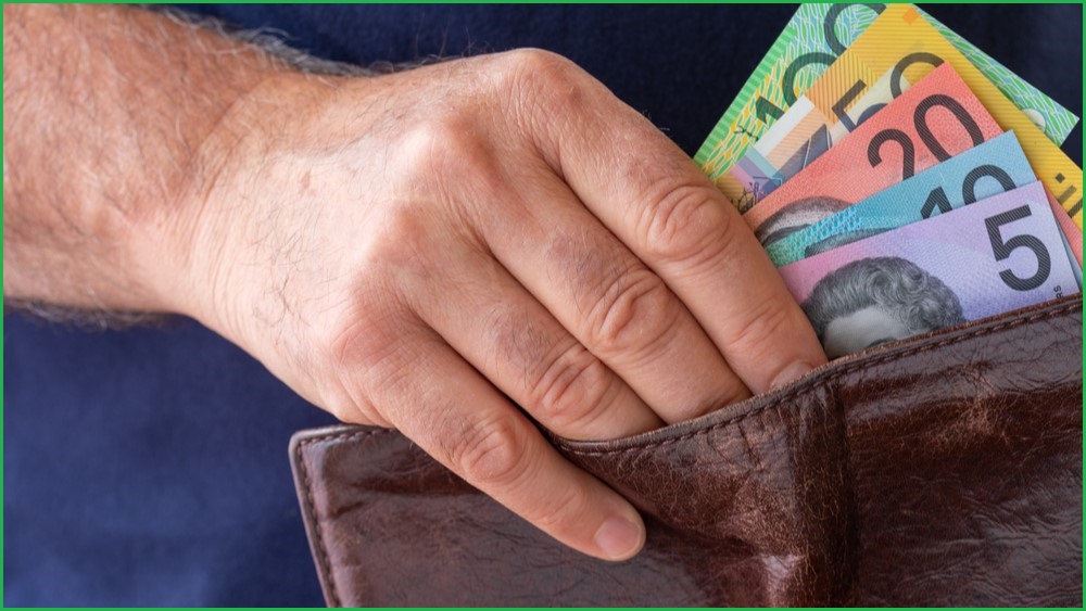 Man pulling Australian dollars out of a wallet
