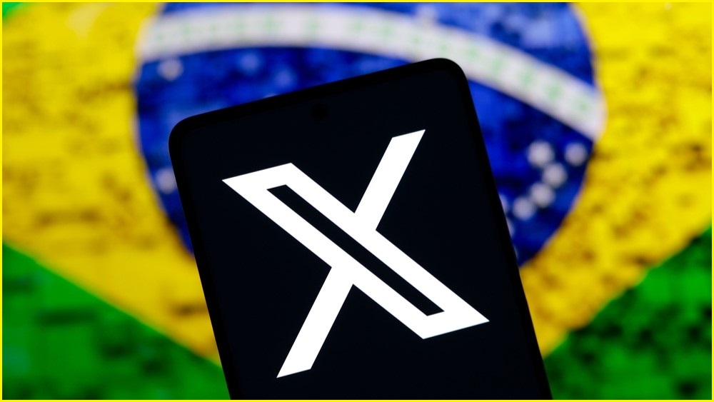 X logo on a phone with a Brazil flag as the background.