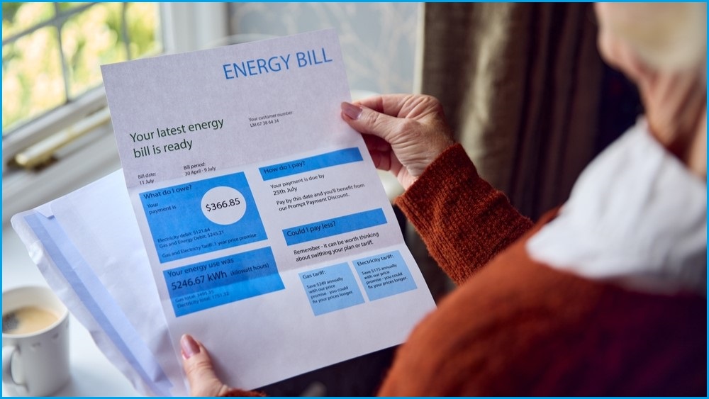 Elderly woman holding open an energy bill.