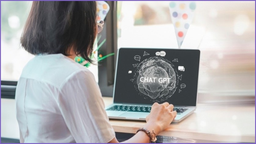 Woman looking at laptop screen featuring the words CHATGPT.