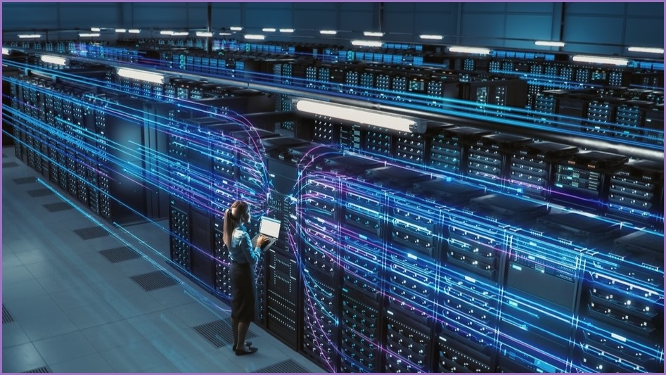 Rows of servers in a data centre with a woman watching them.