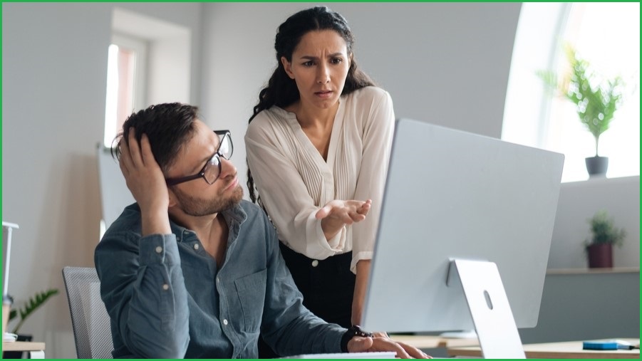 Woman pointing out something out on a screen to a man who is rolling his eyes.