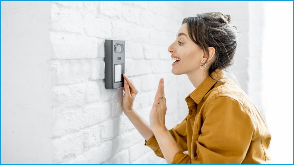 Woman waving to doorbell camera.