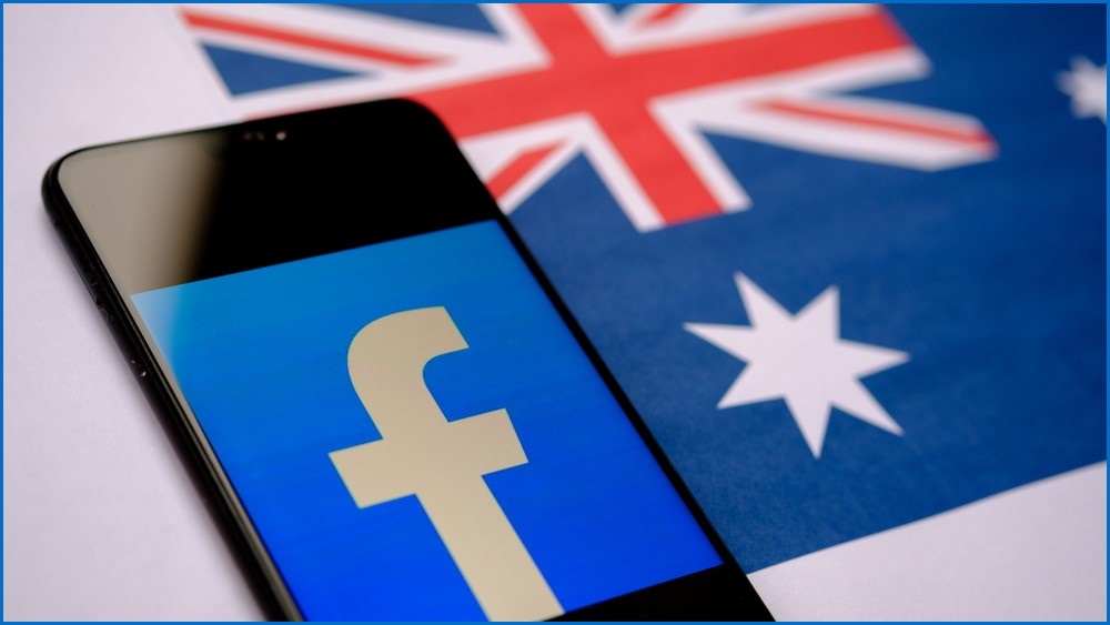 Phone screen displaying Facebook logo with an Australian flag in the background