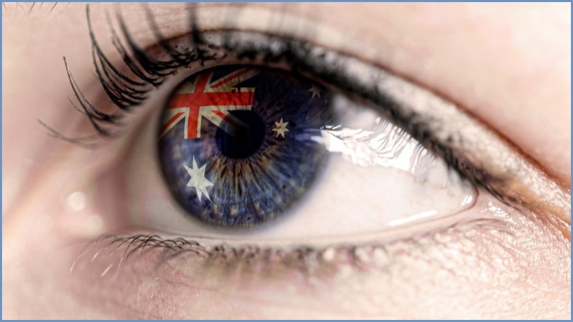 Close up of a person's eye with the Australian flag reflected on their eyeball