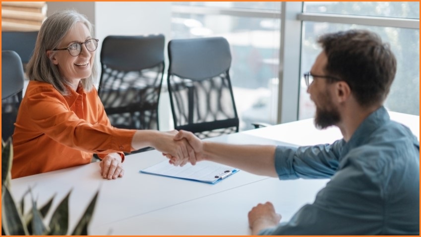 A women interviewing a man for a job.