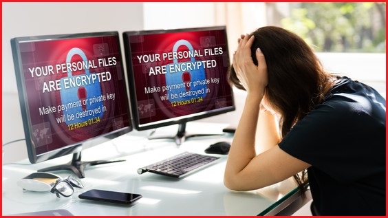Woman at computer with screens showing her files have been locked by ransomware.