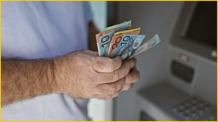 Man taking cash from an ATM.