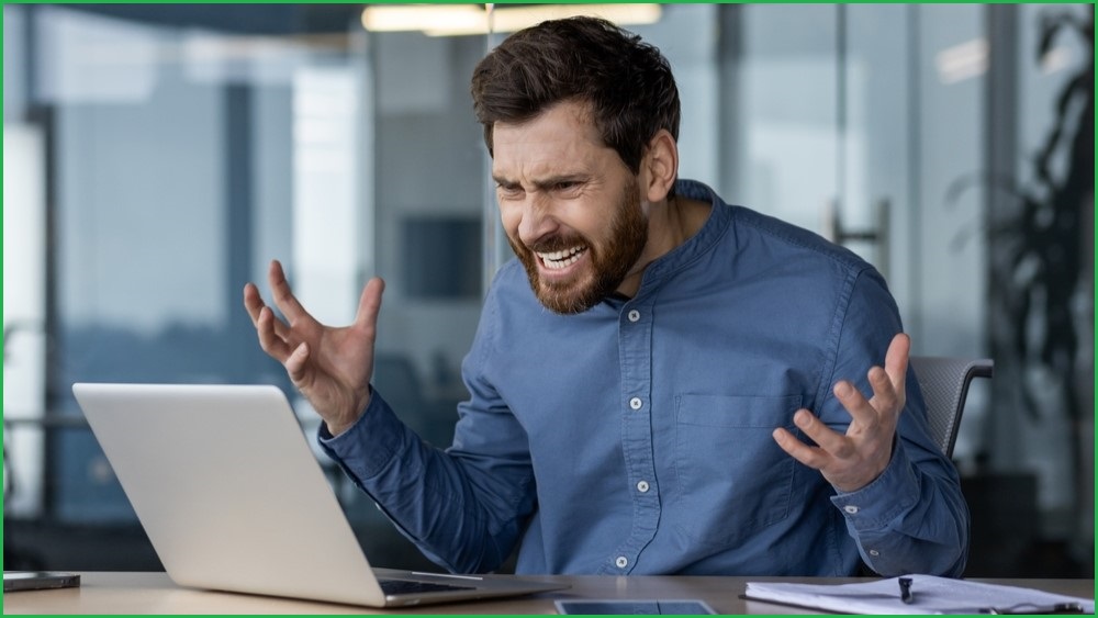 Man frustrated at something on his computer.