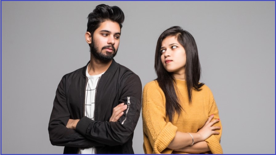 Man and woman with folded arms half looking at each other