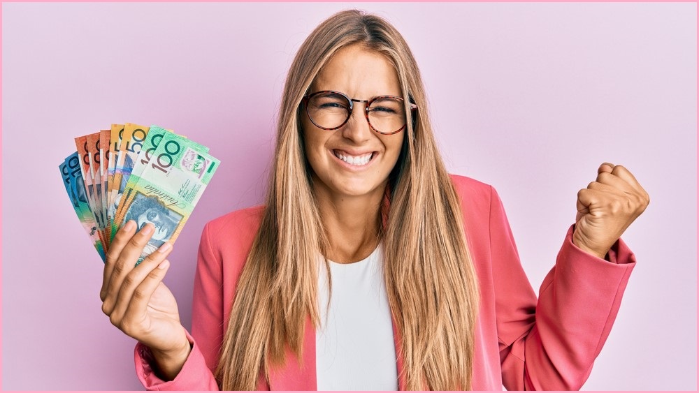 Woman holding Australian dollars, celebrating