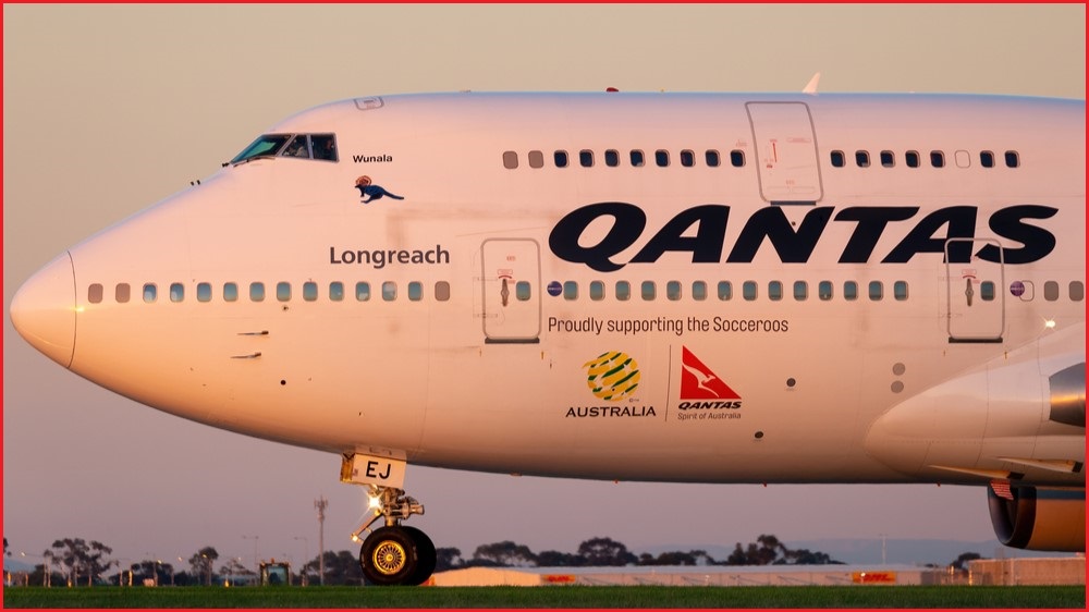 The nose of a Qantas place sitting on a tarmac.