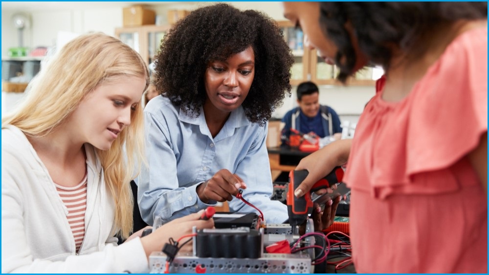 Women working with electronics in a classroom.