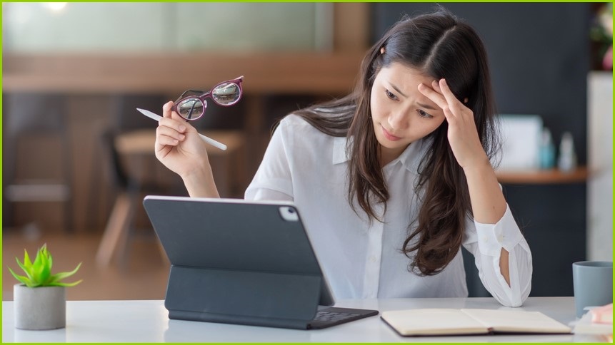 Stressed woman working at a computer.