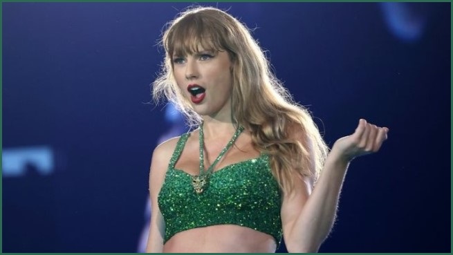 Taylor Swift in a sparkly green crop top.