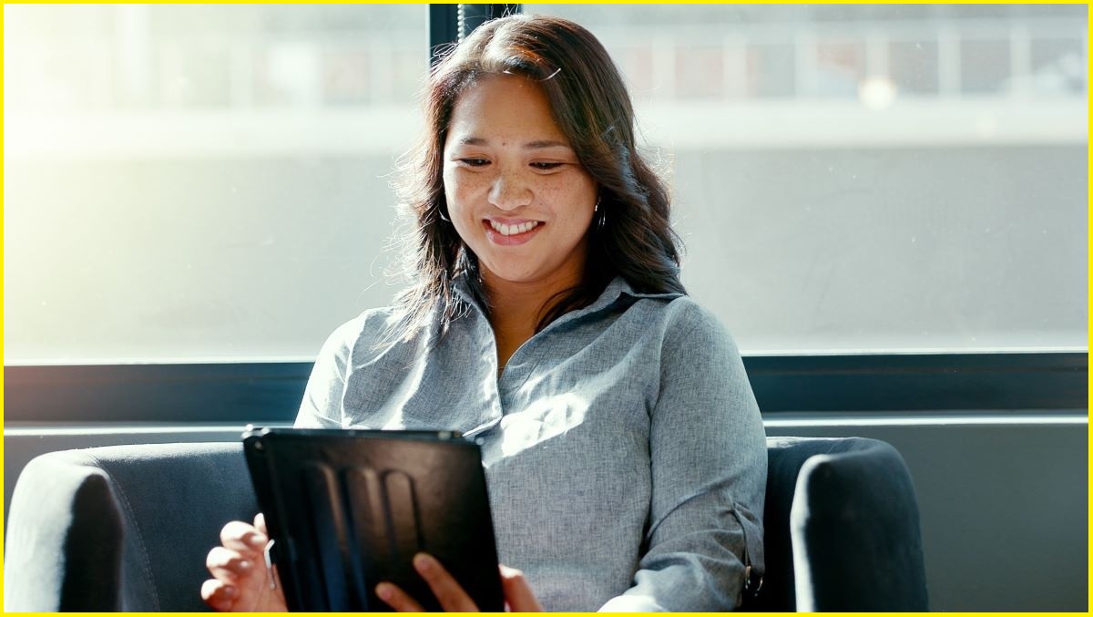 Woman smiling looking at a tablet screen