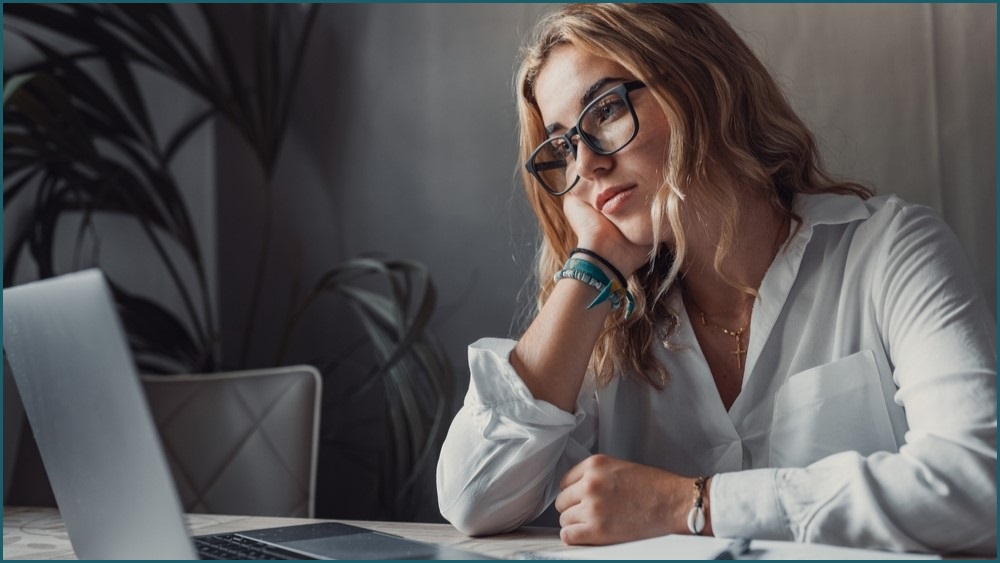 Woman staring wistfully at her computer.