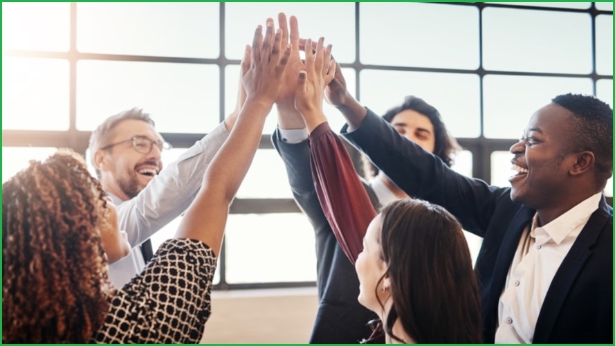 A group of people doing a highfive with each other.