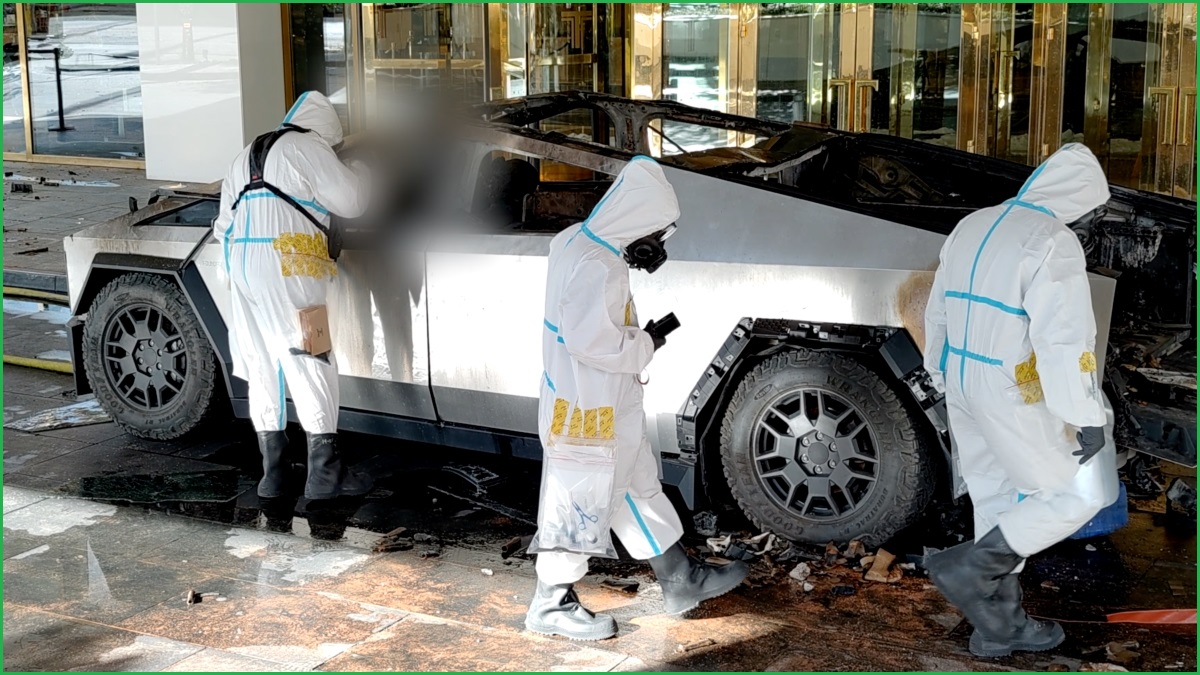 A medium shot of three people in forensics suits walk around a burned out Tesla Cybertruck out the front of a hotel.