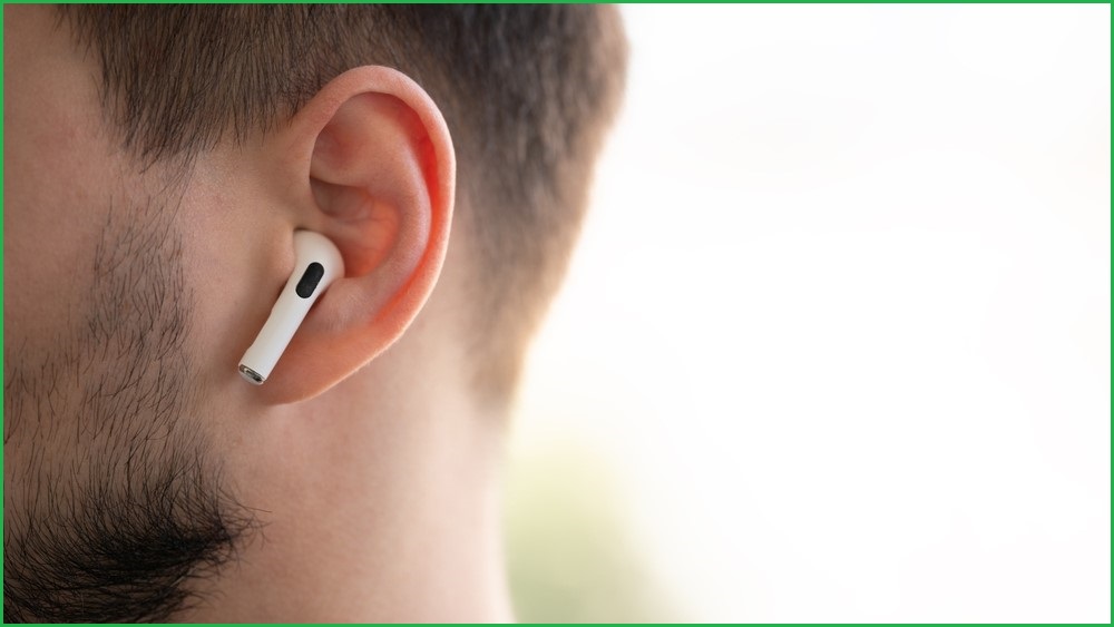 A close up shot of an Apple AirPods Pro 2 earphone in a man's ear.