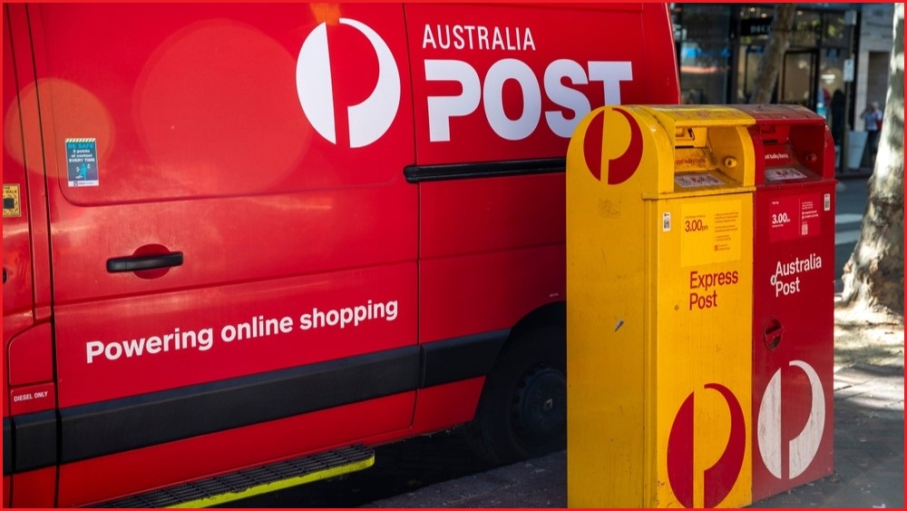 Australia Post van parked next to two post boxes.
