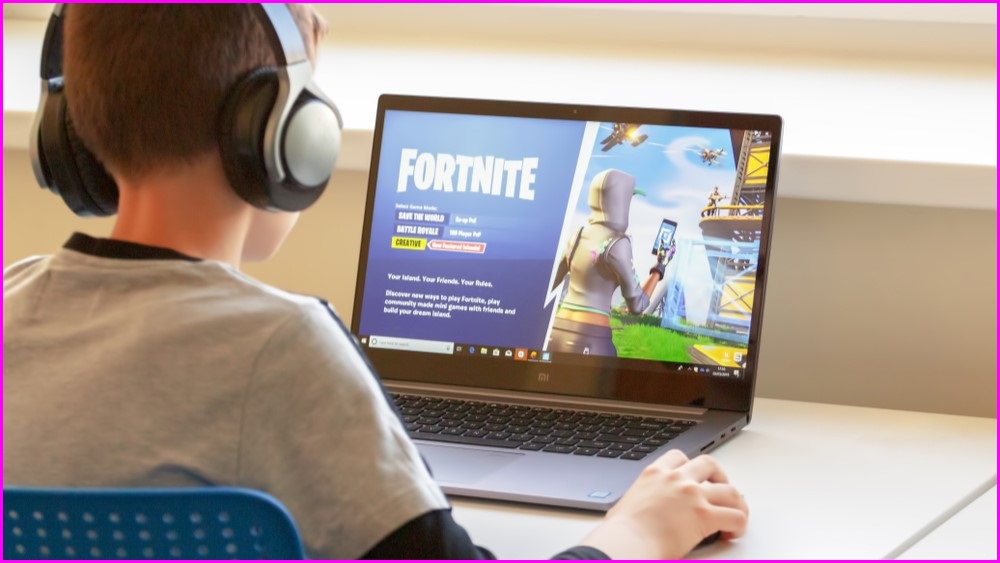 Boy playing Fortnite on a laptop.