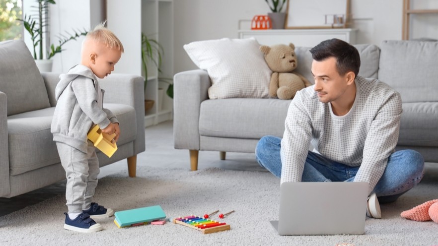 Dad working from home with young child nearby.